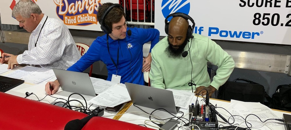 Luke Fay (L) interviews former TCC great Marcus Hatten during halftime at the 2020 FCSAA Men's Basketball State Championship Game